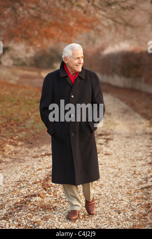 Senior uomo sulla Passeggiata invernale attraverso il pupazzo di neve il paesaggio Foto Stock