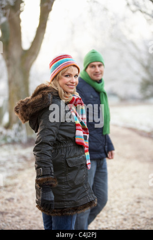 Donna sulla Passeggiata invernale attraverso il pupazzo di neve il paesaggio Foto Stock