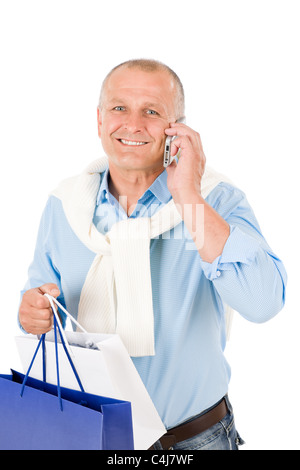 Elegante felice senior uomo con le borse della spesa sul telefono Foto Stock