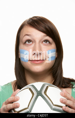 Femmina giovane tifoso di calcio con la bandiera argentina dipinta sul viso Foto Stock