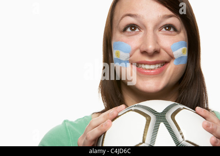 Femmina giovane tifoso di calcio con la bandiera argentina dipinta sul viso Foto Stock