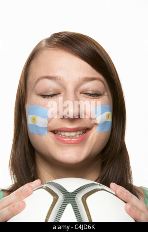 Femmina giovane tifoso di calcio con la bandiera argentina dipinta sul viso Foto Stock