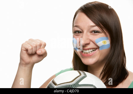 Femmina giovane tifoso di calcio con la bandiera argentina dipinta sul viso Foto Stock