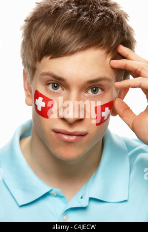 Deluso maschi giovani appassionati di sport con la bandiera svizzera dipinto sul volto Foto Stock