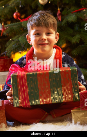 Ragazzo di Natale apertura presente nella parte anteriore della struttura ad albero Foto Stock