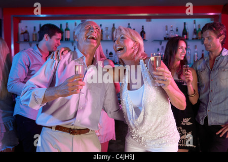 Coppia senior divertirsi nella barra di occupato Foto Stock