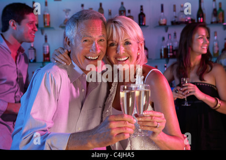Coppia senior divertirsi nella barra di occupato Foto Stock