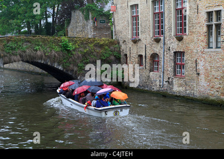 I turisti in una gita in barca con tutti gli ombrelli sollevata in un giorno di pioggia. Foto Stock
