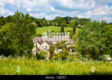 Case e villette nel grazioso villaggio Costwold di Shilton, Oxfordshire, Inghilterra, Regno Unito in una giornata di sole in primavera Foto Stock