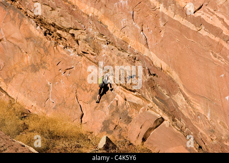 Eldorado Springs, Colorado - un rocciatore in verde risale una scogliera di Eldorado Canyon State Park. Foto Stock