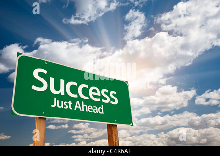 Successo cartello verde contro le nubi e Sunburst. Foto Stock
