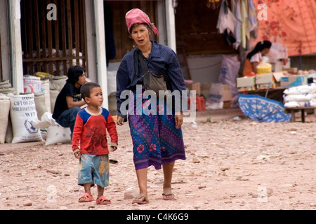 Un etnica hilltribe donna è a piedi con un giovane ragazzo in un mercato in Laos comunista. Foto Stock