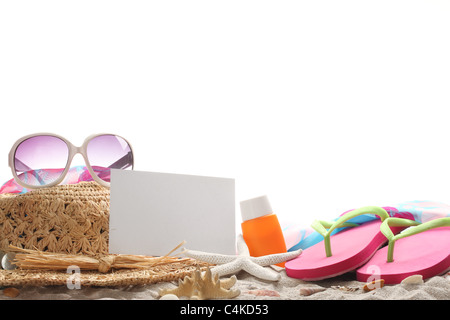 Accessori da spiaggia con cappello di paglia,occhiali da sole,protezione solare, flip-flop e la scheda vuota sulla sabbia. Foto Stock