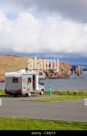 Eshaness, isole Shetland, Scotland, Regno Unito. Camper in campeggio Braewick affacciato sul mare Drongs pile sulla costa frastagliata Foto Stock