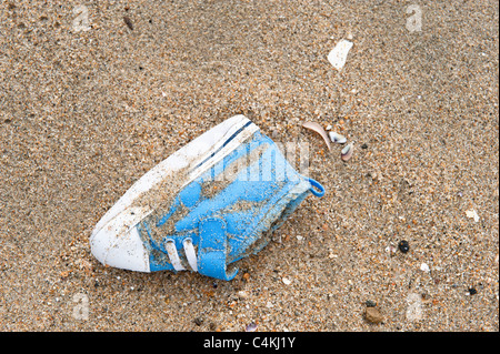 Una scarpa bambino perso e abbandonato sulla spiaggia. Foto Stock