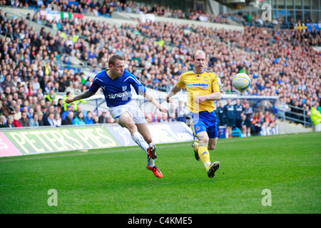 Craig Bellamy (sinistra) di Cardiff City FC di tentare una croce passato Gareth Roberts (destra) del Derby County FC, 02 aprile 2011 Foto Stock