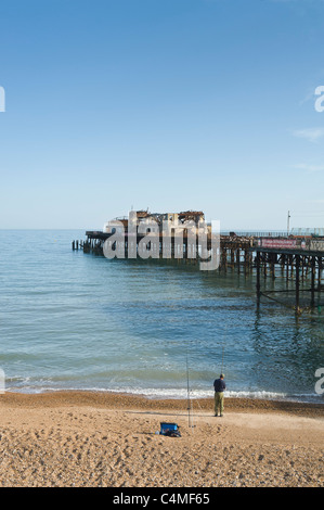 Uomo di pesca da Hastings Pier Maggio 2011. Nel 2010 il molo è stata gravemente danneggiata da un incendio. Sussex Regno Unito Foto Stock