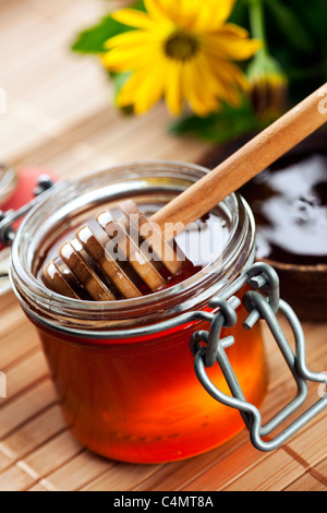 Il miele drizzler all'interno del vasetto di miele Foto Stock