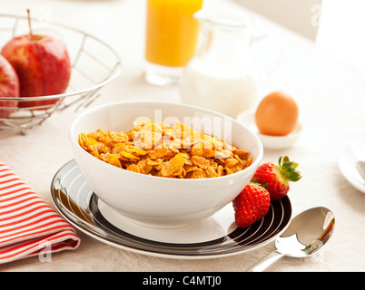 Sana colazione con fiocchi di mais, fragole, mele, succo d'arancia, uova e latte Foto Stock