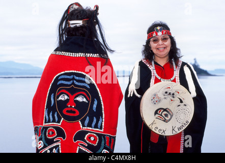 Due Tlingit Native American donne display tradizionale capes progettato con pulsanti e un tamburo della tribù Keex (kwaan) a Kake, Alaska, Stati Uniti d'America. Foto Stock