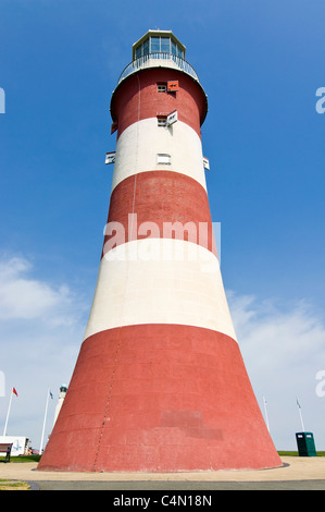 Compressa verticale vista prospettica della rossa e bianca a strisce Smeaton torre del faro a Plymouth Hoe in una giornata di sole. Foto Stock