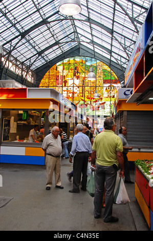 Vista lungo una fila di platea verso la vetrata presso il mercato coperto (Mercado de Atarazanas), Malaga, Spagna. Foto Stock