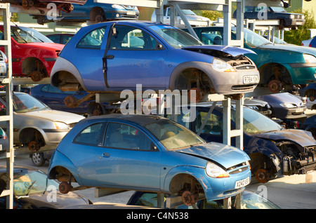 Vetture impilati in un scrapyard. Foto Stock