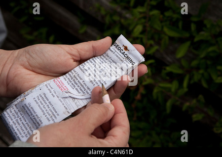 Una persona che tiene un registro di carta per un geocache Foto Stock