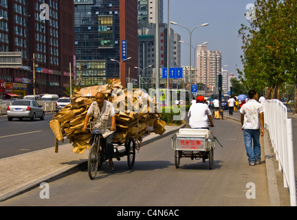 Pechino, Cina, scena di strada occupato nell'area commerciale, vicino al Centro commerciale di lusso, uomini di consegna rickshaw, strada della città cinese, lavoro precario Foto Stock