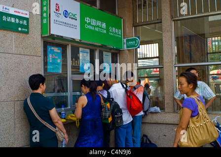 Pechino, Cina, Cinese Teens ritirare contanti dal banco della macchina su strada Foto Stock