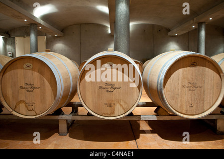 Oak botti da vino in grotta presso Chateau Beau-Sejour Becot a St Emilion nella regione dei vini di Bordeaux di Francia Foto Stock