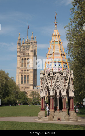 Buxton Memorial Fontana e il Palazzo di Westminster giardini con la torre di Victoria dietro, Palazzo di Westminster, Londra, Regno Unito. Foto Stock