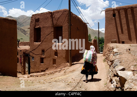 Donna iraniana a piedi nel tradizionale villaggio di fango di Abyaneh, Iran Foto Stock