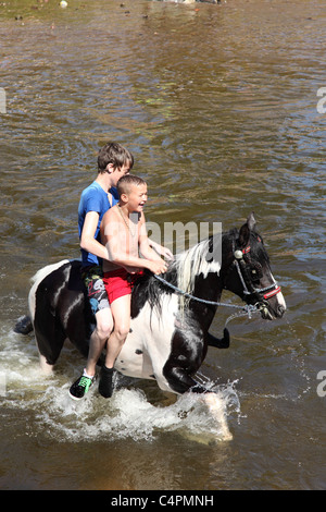 Ragazzi zingari nuoto un cavallo a Appleby Horse Fair, Appleby-In-Westmorland, Cumbria, England, Regno Unito Foto Stock