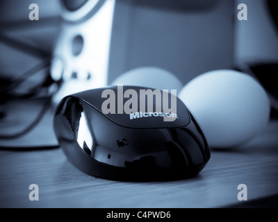 Microsoft mouse vicino ad alcune uova su una scrivania in blue tech luce. Foto Stock