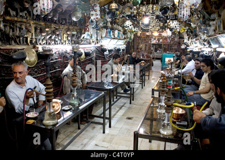 Il popolo iraniano, clienti, utenti, uomini di bere e fumare a Azadegan tea house Isfahan, Iran Foto Stock