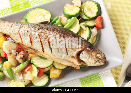 Trota alla griglia servita con verdure miste Foto Stock