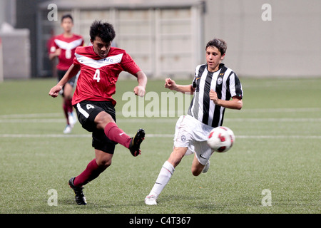 Sadik detto di Singapore U15(sinistra) cancella la palla da Gili Fabio durante la XXIII Canon Lion City Cup. Foto Stock