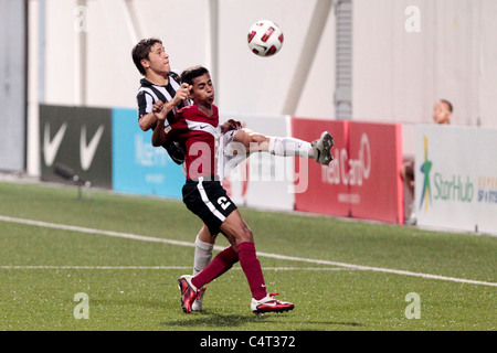 Gili Fabio della Juventus FC U15 e Ehvin Sasidharan bloccato in una battaglia per la sfera allentati durante il ventitreesimo Canon Lion City Cup. Foto Stock