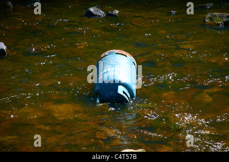 Bombola di gas oggetto di dumping in un fiume Foto Stock