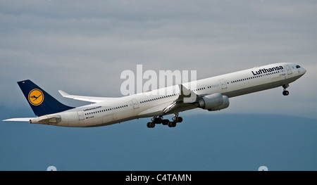 Un basso angolo di visione di un Lufthansa Airbus A340-600 aereo jet come si decolla dall'Aeroporto Internazionale di Vancouver. Foto Stock