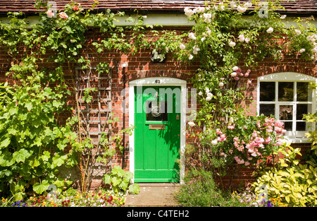 Villaggio inglese cottage con rose a fiore intorno alla porta, Orford , Suffolk REGNO UNITO Foto Stock