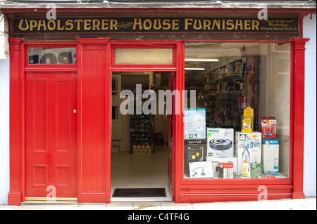Un piccolo negozio di essere rinnovato, che mostra la vecchia originale cartellonistica per tappezzieri e casa Furnisher Pier St Aberystwyth Wales UK Foto Stock
