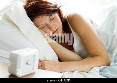 La donna dorme nel letto Foto Stock