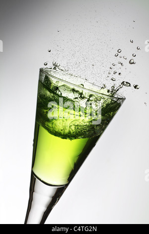 Splash in un bicchiere, verde assenzio. Foto Stock