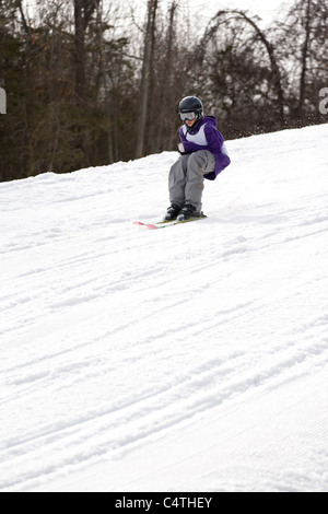 Un giovane sciatore freestyle sciare giù per la montagna senza bastoncini da sci. Foto Stock