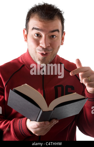 Un giovane uomo che legge un libro con un espressione di sorpresa sul suo volto. Foto Stock