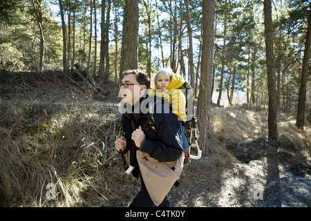 Padre escursioni nei boschi con la nostra bambina nello zaino carrier Foto Stock