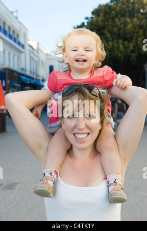 Madre che trasportano bambina sulle sue spalle, ritratto Foto Stock