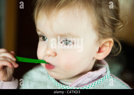 Il Toddler girl alimentare se stessa, ritratto Foto Stock